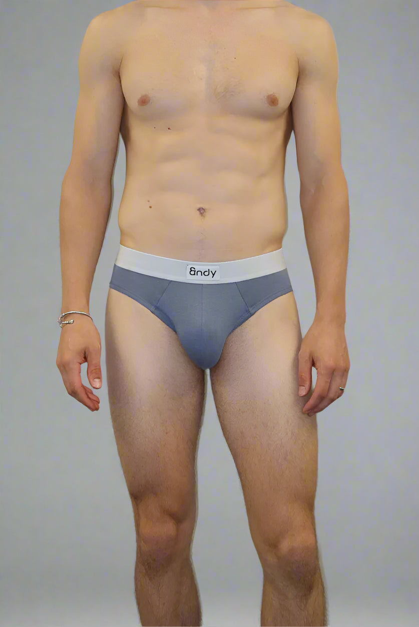 Man wearing gray underwear standing against a plain wall.