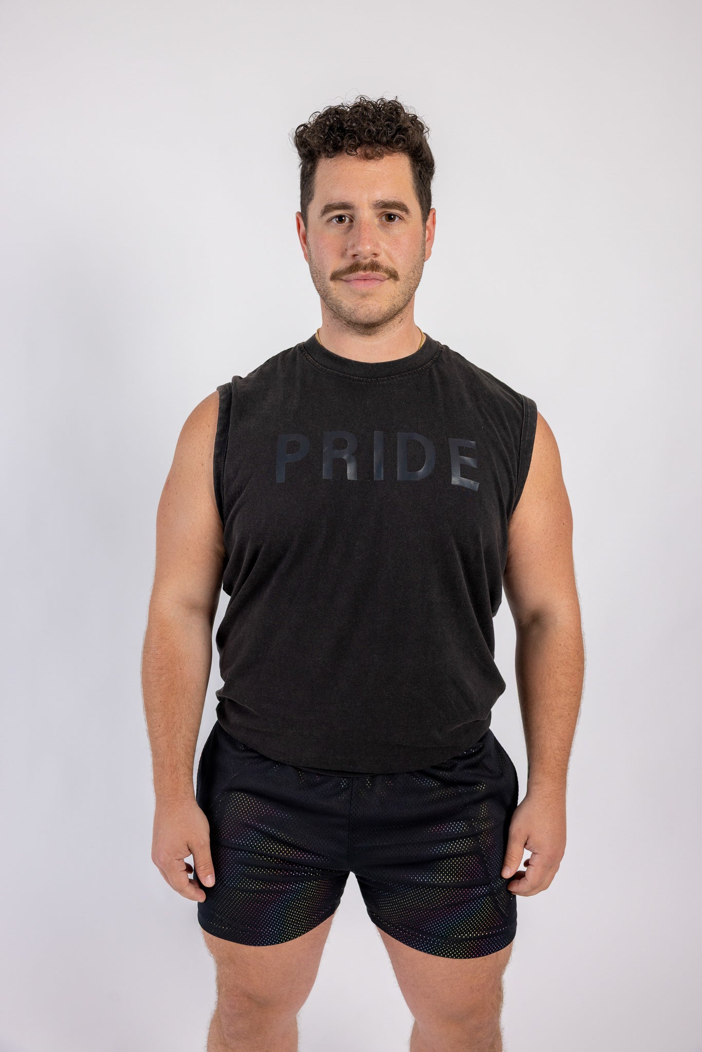 Man wearing a black sleeveless shirt with 'PRIDE' text on a white background