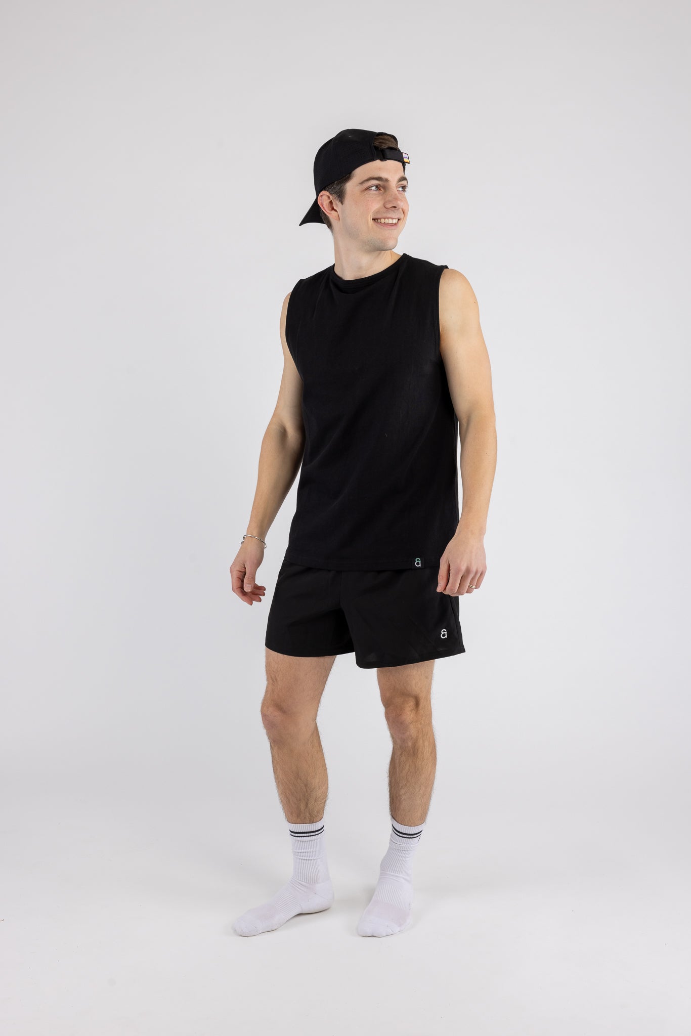 Person wearing a black sleeveless shirt and shorts on a white background