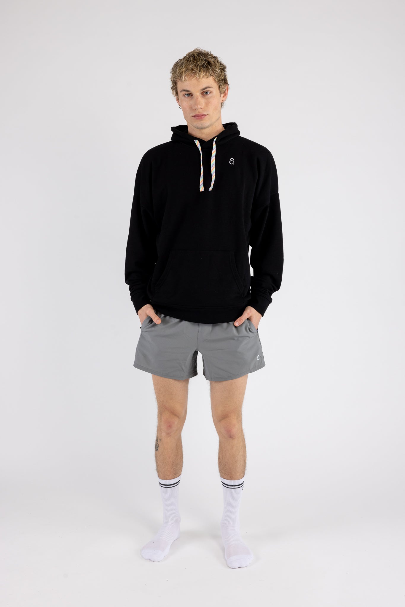 Man wearing the Arco Hoodie and Gray Prism Shorts