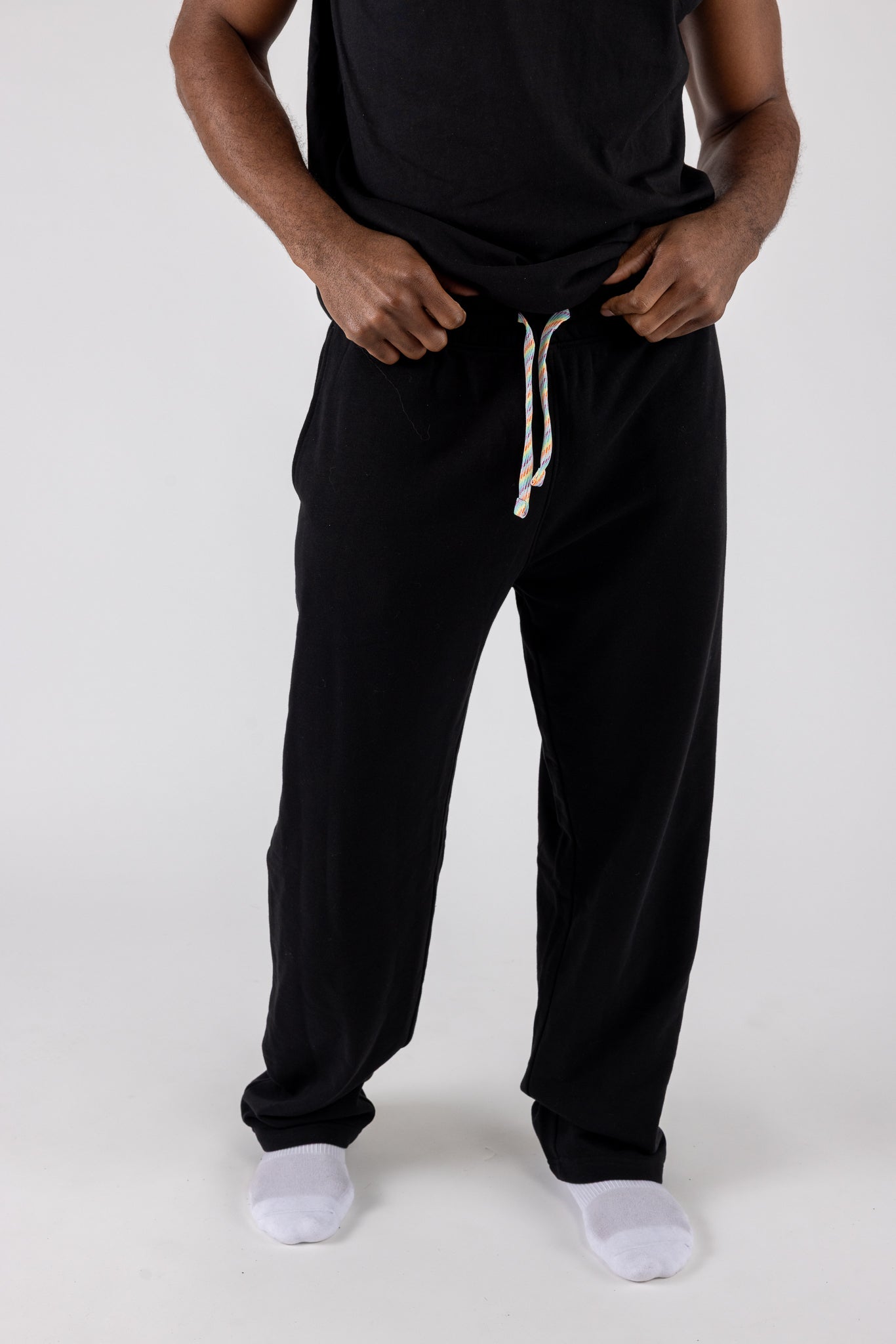 Person wearing black drawstring pants on a white background