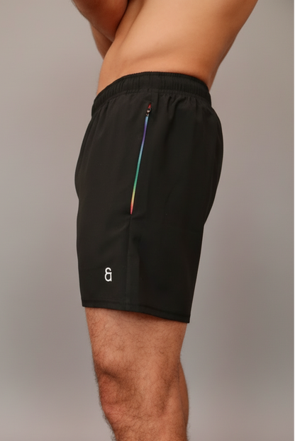 Black shorts with a colorful zipper on a neutral background