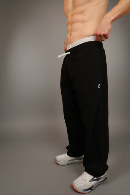 Person wearing black pants and white sneakers in a room with lockers.