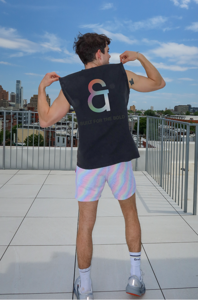 Person wearing a black t-shirt with a logo on a rooftop with a cityscape in the background