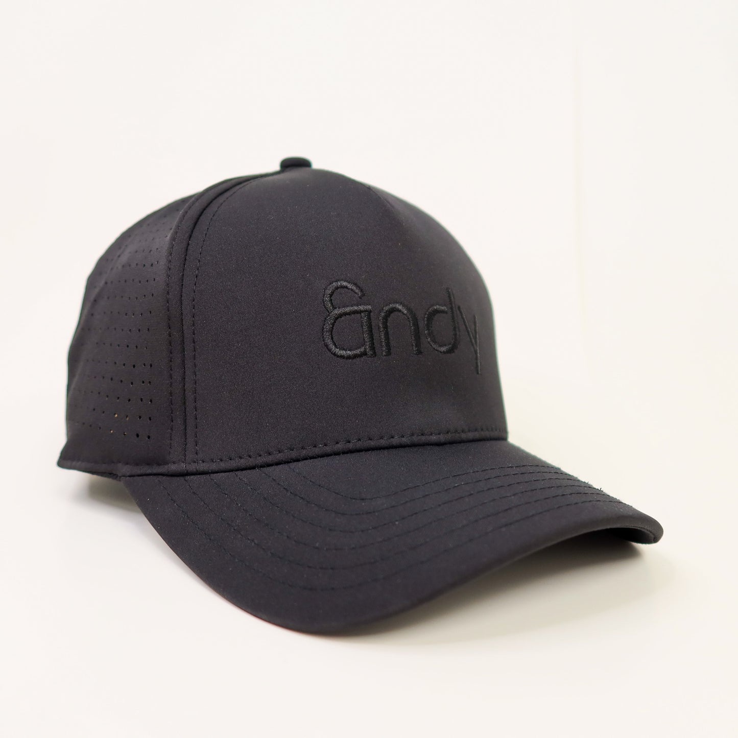 Black cap with a brand logo on a light gray background